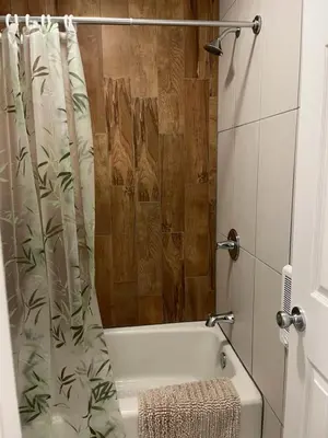 a bathroom with a bath tub with a shower curtain at High Point Mountain Motel in Wantage