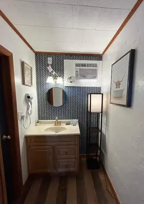 a bathroom with a sink and a microwave at High Point Mountain Motel in Wantage