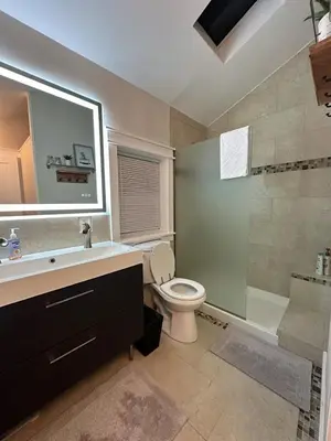 a bathroom with a toilet and a sink and a shower at Lovely private home in a serene neighborhood in Totowa