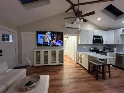 a living room with a kitchen with a flat screen tv at Lovely private home in a serene neighborhood in Totowa