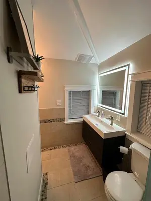 a bathroom with a sink and a toilet and a mirror at Lovely private home in a serene neighborhood in Totowa