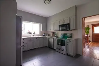 a kitchen with white cabinets and white appliances at Dancing Doe Estate - Delaware Valley Escape with Wood Stove and Hot Tub in Jeffersonville