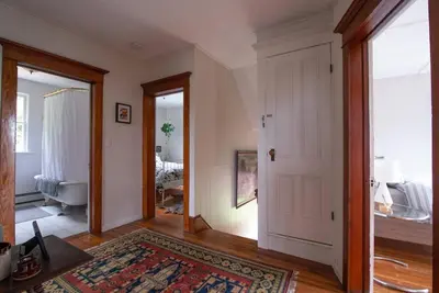 a living room with a door leading to a bathroom at Dancing Doe Estate - Delaware Valley Escape with Wood Stove and Hot Tub in Jeffersonville