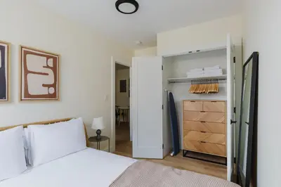 a bedroom with a white bed and a closet at Blueground Greenpoint wd ac near ferry NYC-1538 in New York
