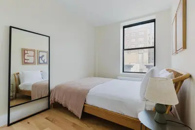 a bedroom with a mirror and a bed at Blueground Greenpoint wd ac near ferry NYC-1538 in New York