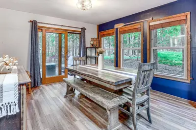 a dining room with a wooden table and chairs at Pocono Lake Retreat Ski and Explore at Pine Loch! in Pocono Lake