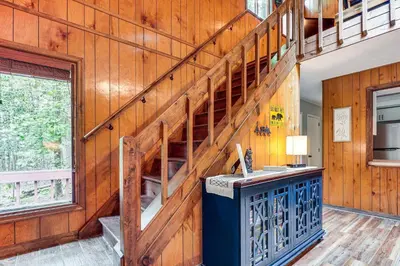a room with a wooden wall with a staircase at Pocono Lake Retreat Ski and Explore at Pine Loch! in Pocono Lake