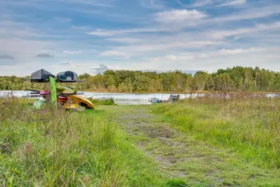 a bike parked in a field next to a body of water at Pocono Lake Retreat Ski and Explore at Pine Loch! in Pocono Lake