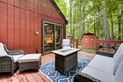 a patio with chairs and a table on a deck at Pocono Lake Retreat Ski and Explore at Pine Loch! in Pocono Lake