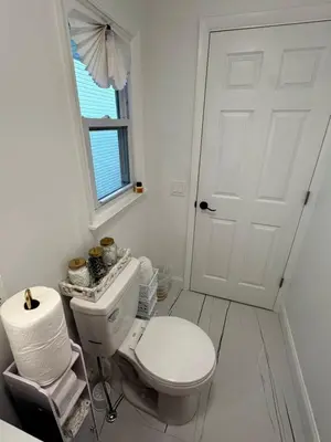a white bathroom with a toilet and a window at Luxurious, newly renovated retreat in Springfield