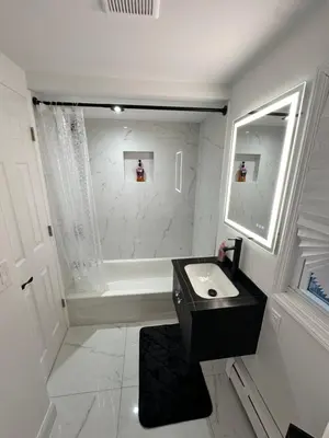 a white bathroom with a sink and a bath tub at Luxurious, newly renovated retreat in Springfield