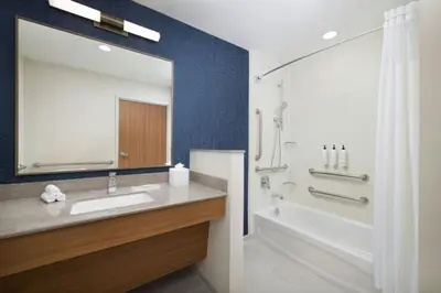 a bathroom with a sink and a tub and a mirror at Fairfield by Marriott Inn & Suites Union in Union