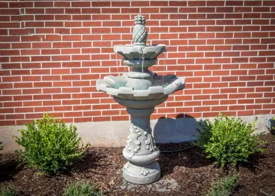 a stone fountain in front of a brick building at The Globe Inn in East Greenville