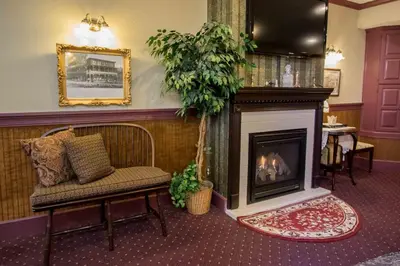 a living room with a fireplace and a chair at The Globe Inn in East Greenville