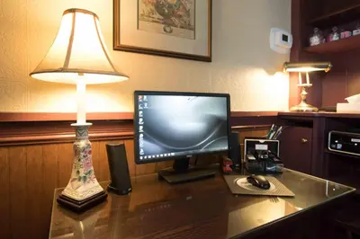 a computer monitor sitting on a desk with a lamp at The Globe Inn in East Greenville