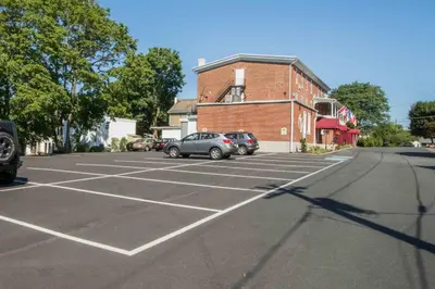 a parking lot with cars parked in front of a brick building at The Globe Inn in East Greenville