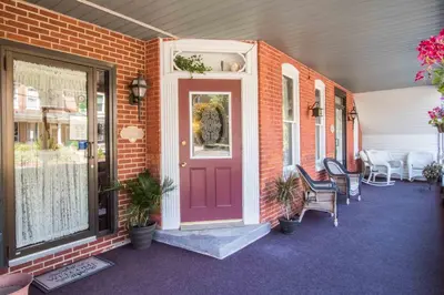 a red door on a house with a table and chairs at The Globe Inn in East Greenville