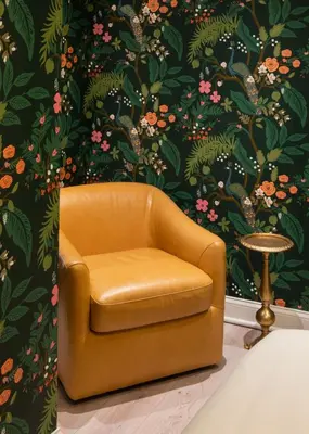 a chair in front of a wall with a floral wallpaper at Modern Marvel at University City in Philadelphia