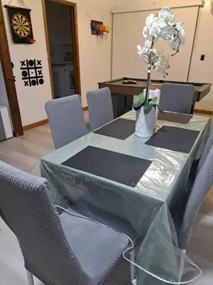 a glass table with chairs and a vase with flowers on it at Fun Home in Pocono with Gameroom-Firpit-BBQ Grill-TV and AC in all rooms in Tobyhanna