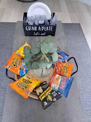 a table with snacks and a potted plant and a plate of chips at Fun Home in Pocono with Gameroom-Firpit-BBQ Grill-TV and AC in all rooms in Tobyhanna