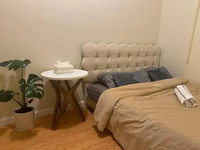 a bedroom with a bed and a table with a plant at Sunny Apt by the park Mins away from midtown New York in Jersey City