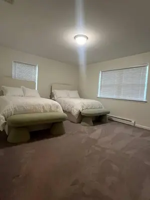 two beds in a room with two windows at Cozy Beautiful Pondside Luxurious Retreat in Monroe