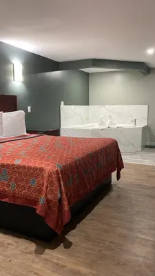 a bedroom with a bed with a red comforter at Wilkes-Barre lodge in Wilkes-Barre