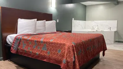 a bedroom with a bed with a red blanket on it at Wilkes-Barre lodge in Wilkes-Barre