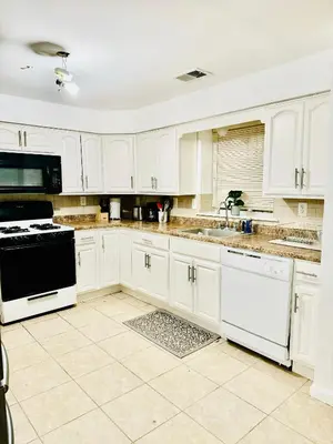 a white kitchen with white cabinets and a sink at Cozy Evergreen Apartment by Newark Airport in Newark