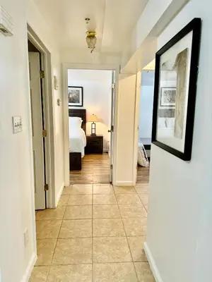 a corridor of a bedroom with a bed and a mirror at Cozy Evergreen Apartment by Newark Airport in Newark