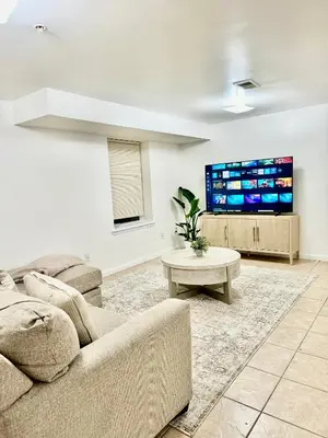 a living room with a couch and a tv at Cozy Evergreen Apartment by Newark Airport in Newark