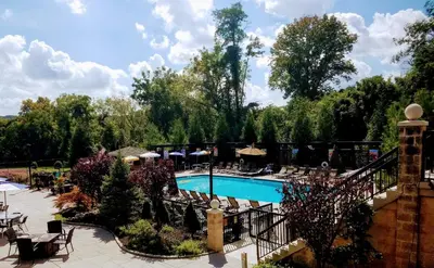 a swimming pool with tables and chairs next to a resort at New Hope Inn & Suites in New Hope