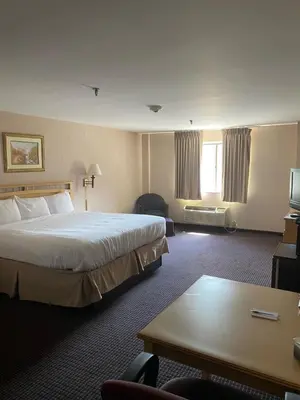 a hotel room with a large bed and a table at Pottsville Hotel in Pottsville