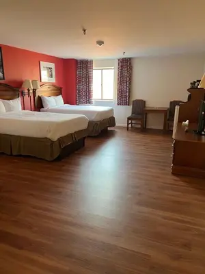 two beds in a hotel room with red walls at Pottsville Hotel in Pottsville