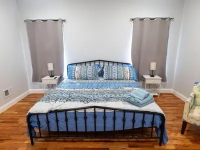 a bedroom with a blue bed with two night stands at 4 New Apts - 3 Bed Apt 1st Floor & 3 Bed Apt 2nd Floor - 1 Bed Studio Apt Ground Floor & 1 Bed Studio Apt Ground Floor near Penn Station EWR Airport Beth Israel Hospital Manhattan NYC in East Orange
