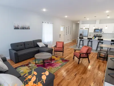a living room with a couch and chairs and a kitchen at 4 New Apts - 3 Bed Apt 1st Floor & 3 Bed Apt 2nd Floor - 1 Bed Studio Apt Ground Floor & 1 Bed Studio Apt Ground Floor near Penn Station EWR Airport Beth Israel Hospital Manhattan NYC in East Orange