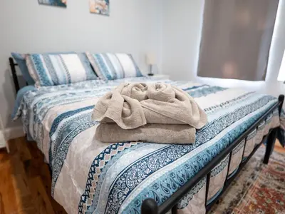 a bed with a pile of towels sitting on it at 4 New Apts - 3 Bed Apt 1st Floor & 3 Bed Apt 2nd Floor - 1 Bed Studio Apt Ground Floor & 1 Bed Studio Apt Ground Floor near Penn Station EWR Airport Beth Israel Hospital Manhattan NYC in East Orange
