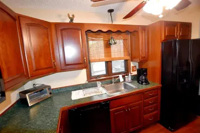 a kitchen with a sink and a black refrigerator at Ski-In Ski-Out Camelback Village Townhouse - 100 YDS From The Mountain in Crescent Lake