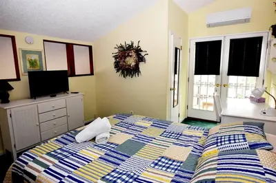 a bedroom with a bed and a tv and windows at Ski-In Ski-Out Camelback Village Townhouse - 100 YDS From The Mountain in Crescent Lake
