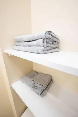a white shelf with towels on top of it at 1BR Apt In Darby 18Min To Lincoln Financial Field in Darby