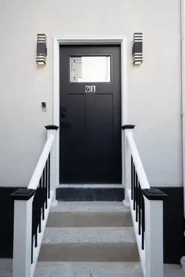 a black door on a white building with stairs at 1BR Apt In Darby 18Min To Lincoln Financial Field in Darby