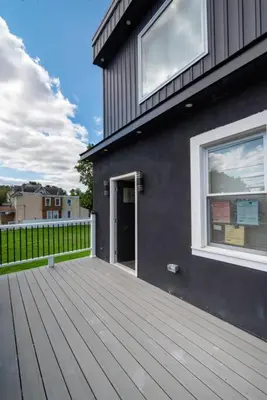 a house with a wooden deck next to a building at Charming 2BR Apt Balcony Views of Darby Creek in Darby