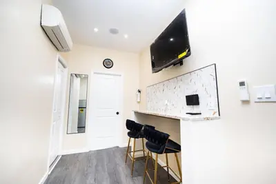 a room with a bar with stools and a tv at Charming 2BR Apt Balcony Views of Darby Creek in Darby