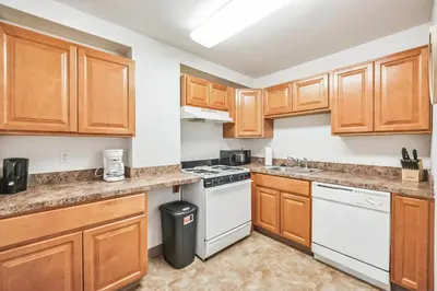 a kitchen with wooden cabinets and white appliances at PP 1002 Modern Corporate 2br, pool, Gym in Harrisburg