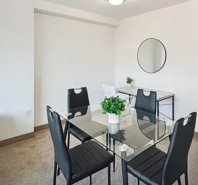 a dining room with a glass table and black chairs at PP 1002 Modern Corporate 2br, pool, Gym in Harrisburg