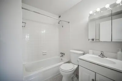 a white bathroom with a toilet and a sink at PP 1301 Modern Corporate 2br, pool, Gym in Harrisburg