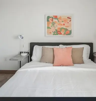 a white bed with pillows and a painting on the wall at PP 1301 Modern Corporate 2br, pool, Gym in Harrisburg