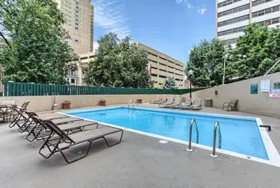 a swimming pool with chaises and chairs next to a building at PP 1301 Modern Corporate 2br, pool, Gym in Harrisburg