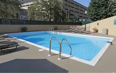 a large swimming pool with chairs next to a building at PP 1306 Modern Corporate 1br, pool, Gym in Harrisburg