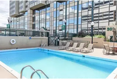 a large swimming pool with chairs and a building at PP 1306 Modern Corporate 1br, pool, Gym in Harrisburg